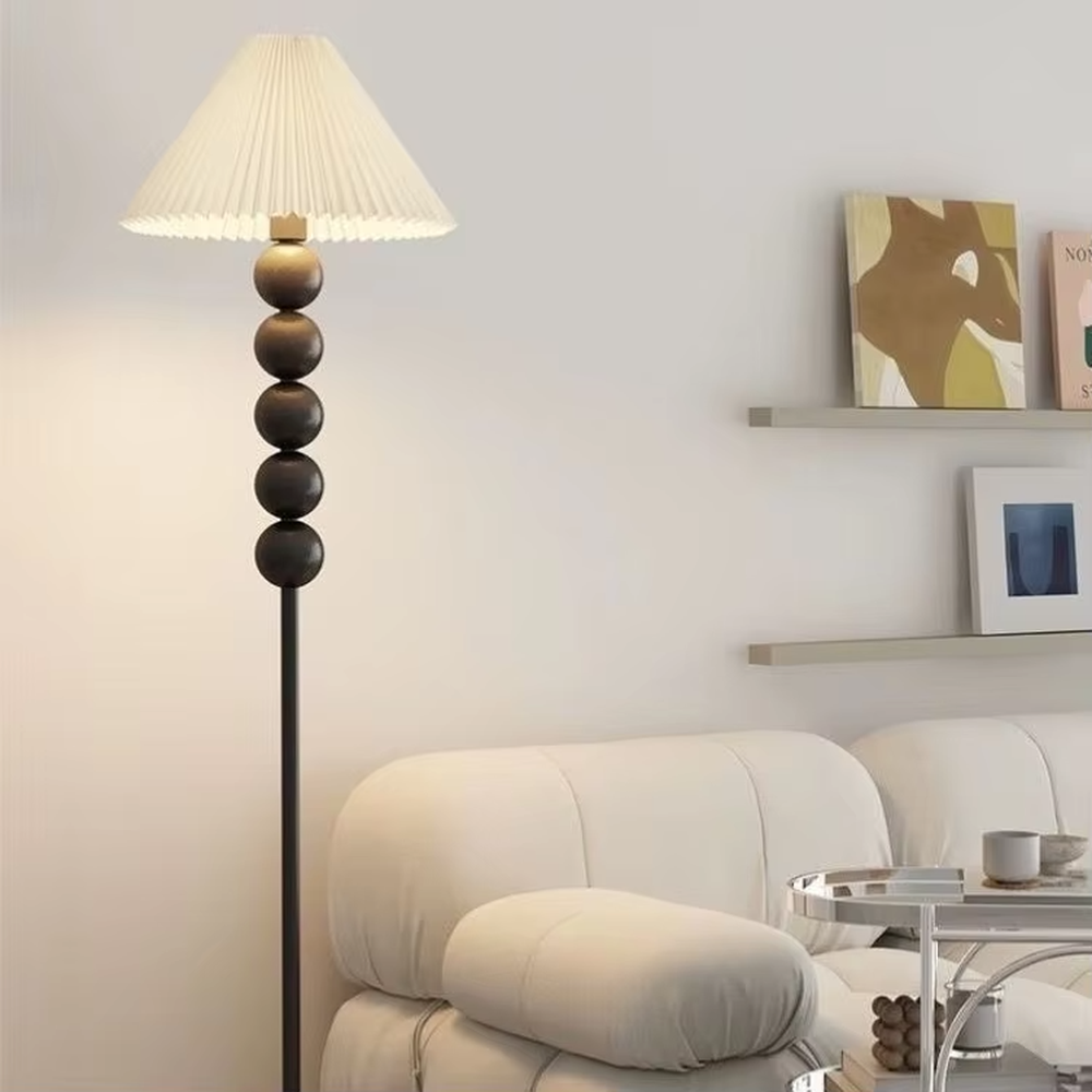 This is a modern warm-style black spherical decorative floor lamp, with a black metal pole featuring spherical decorative elements and a brown fabric lampshade. It has a minimalist and textured design, with soft lighting. It is used for space lighting and decoration, creating a warm and comfortable atmosphere. Suitable for modern minimalist bedrooms, living room corners, Nordic-style homes and other places.