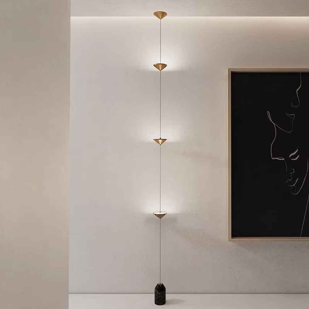 This is a modern artistic golden conical long-string chandelier, with multiple golden conical lamp bodies connected in series and a black marble base, featuring a minimalist artistic design and modern style. It is used for space lighting and decoration, creating an artistic and modern atmosphere. Suitable for modern art home stairwells, high-ceilinged living rooms, designer studios and other places.