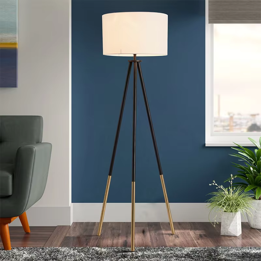 This is a modern tripod - shaped floor lamp with a black - gold metal tripod stand and a dark brown fabric cylindrical lampshade, featuring a minimalist luxury design with strong modern sense. It is used for space lighting and decoration, creating a warm and luxurious atmosphere. It is suitable for modern home living rooms, luxury - style residences, leisure reading areas and other places.