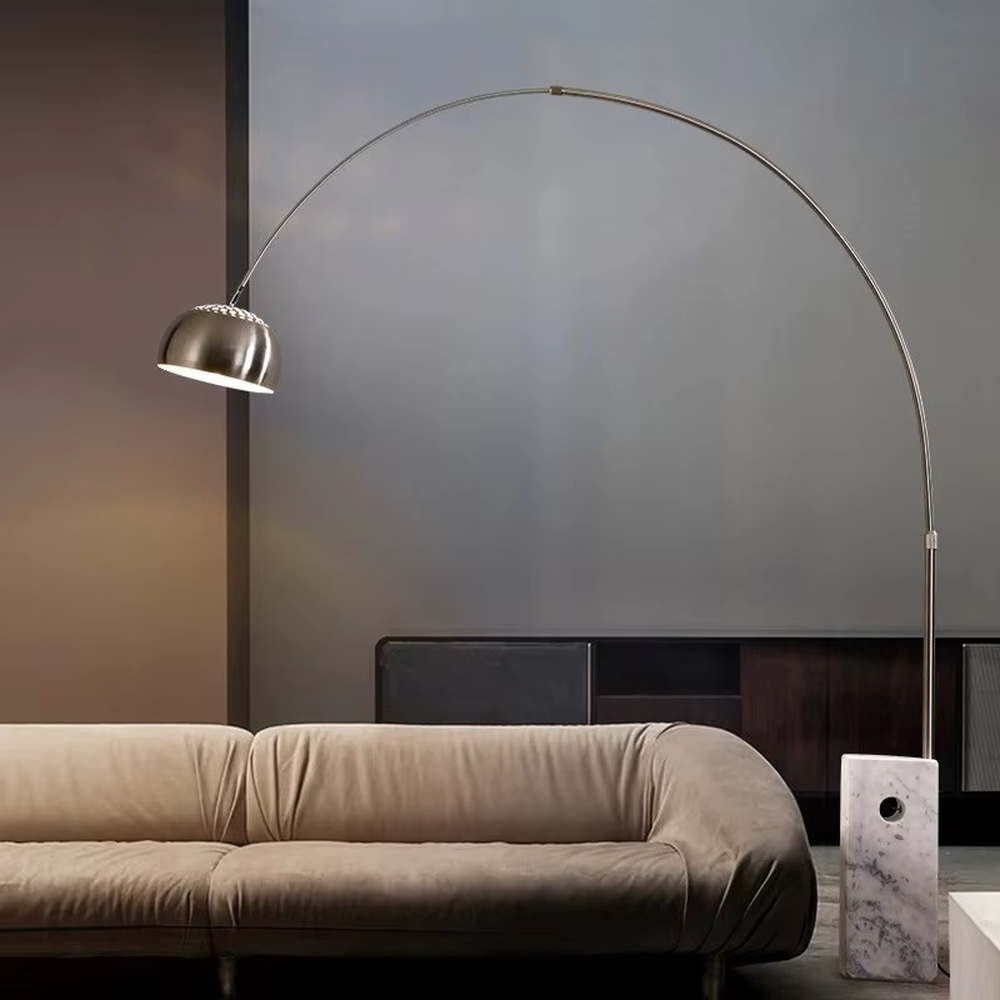 This is a modern luxury arc floor lamp with a golden curved lamp pole, a black marble base, and a golden dome lampshade. It features a simple and elegant design, combining artistry and practicality. It is used for space lighting and decoration, creating a luxurious and fashionable ambiance. It is suitable for modern home living rooms, luxury apartment living areas, high-end hotel leisure spaces and other places.