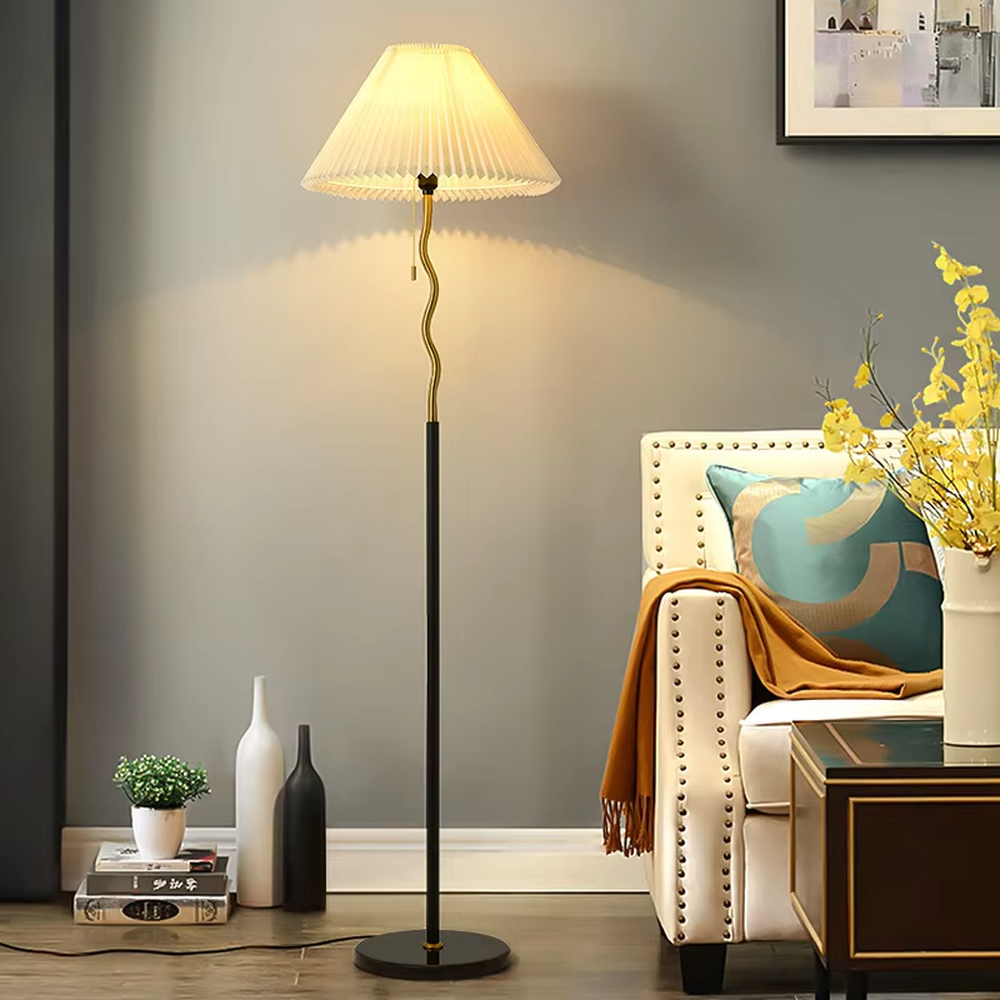 This is a modern minimalist black spherical decorative floor lamp, with a black metal pole featuring spherical decorative elements and a beige pleated fabric lampshade. It has a minimalist and textured design, with soft and warm lighting. It is used for space lighting and decoration, creating a warm and comfortable atmosphere. Suitable for modern minimalist living rooms, bedroom corners, Nordic-style homes and other places.