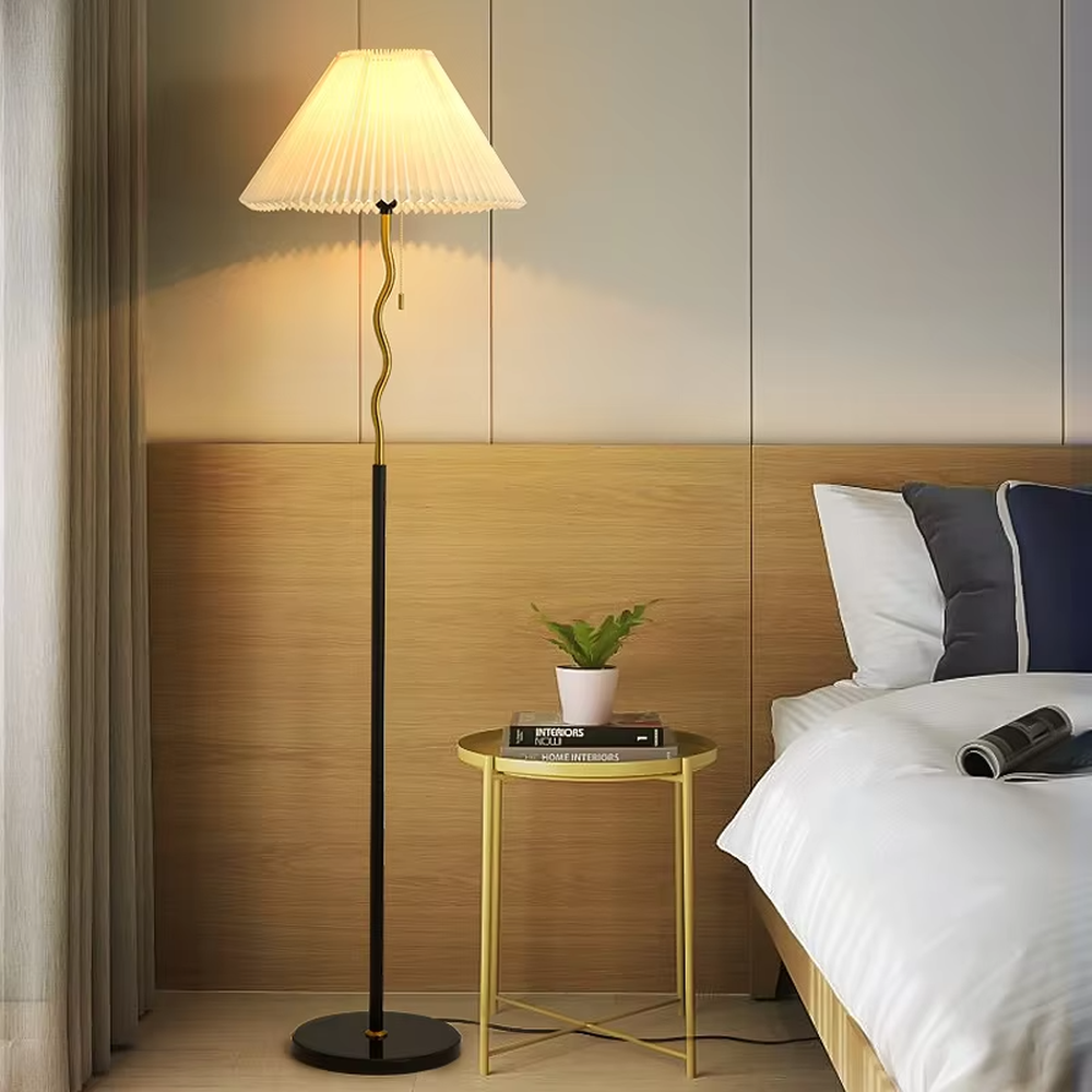 This is a modern minimalist black spherical decorative floor lamp, with a black metal pole featuring spherical decorative elements and a beige pleated fabric lampshade. It has a minimalist and textured design, with soft and warm lighting. It is used for space lighting and decoration, creating a warm and comfortable atmosphere. Suitable for modern minimalist living rooms, bedroom corners, Nordic-style homes and other places.