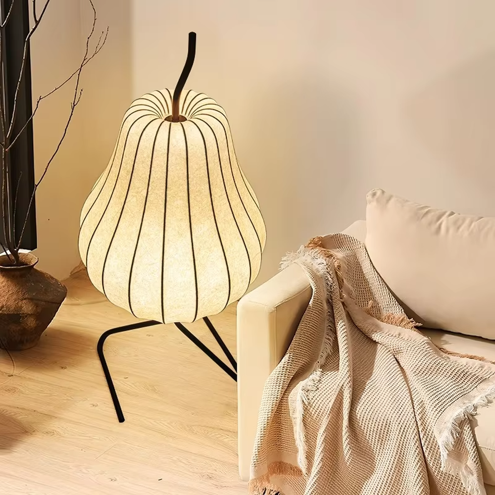 This is a childlike artistic pear-shaped floor lamp, made of paper-like material to create a pear shape, paired with a black metal stand. It features a childlike and natural design, with warm and soft lighting. It is used for space ambient lighting and decoration, creating a childlike and natural atmosphere. Suitable for Nordic-style homes, literary homestays, children's rooms and other places.