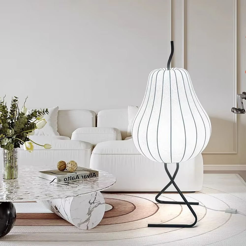 This is a childlike artistic pear-shaped floor lamp, made of paper-like material to create a pear shape, paired with a black metal stand. It features a childlike and natural design, with warm and soft lighting. It is used for space ambient lighting and decoration, creating a childlike and natural atmosphere. Suitable for Nordic-style homes, literary homestays, children's rooms and other places.
