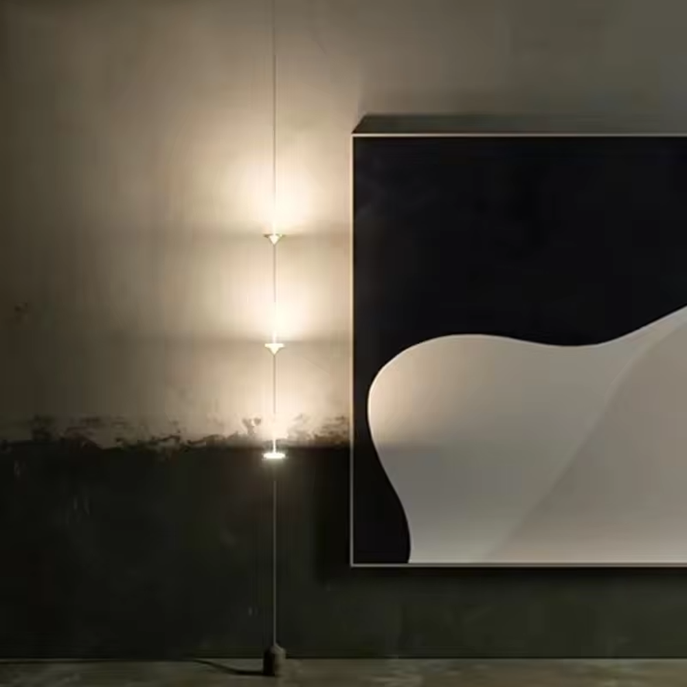 This is a modern artistic golden conical long-string chandelier, with multiple golden conical lamp bodies connected in series and a black marble base, featuring a minimalist artistic design and modern style. It is used for space lighting and decoration, creating an artistic and modern atmosphere. Suitable for modern art home stairwells, high-ceilinged living rooms, designer studios and other places.