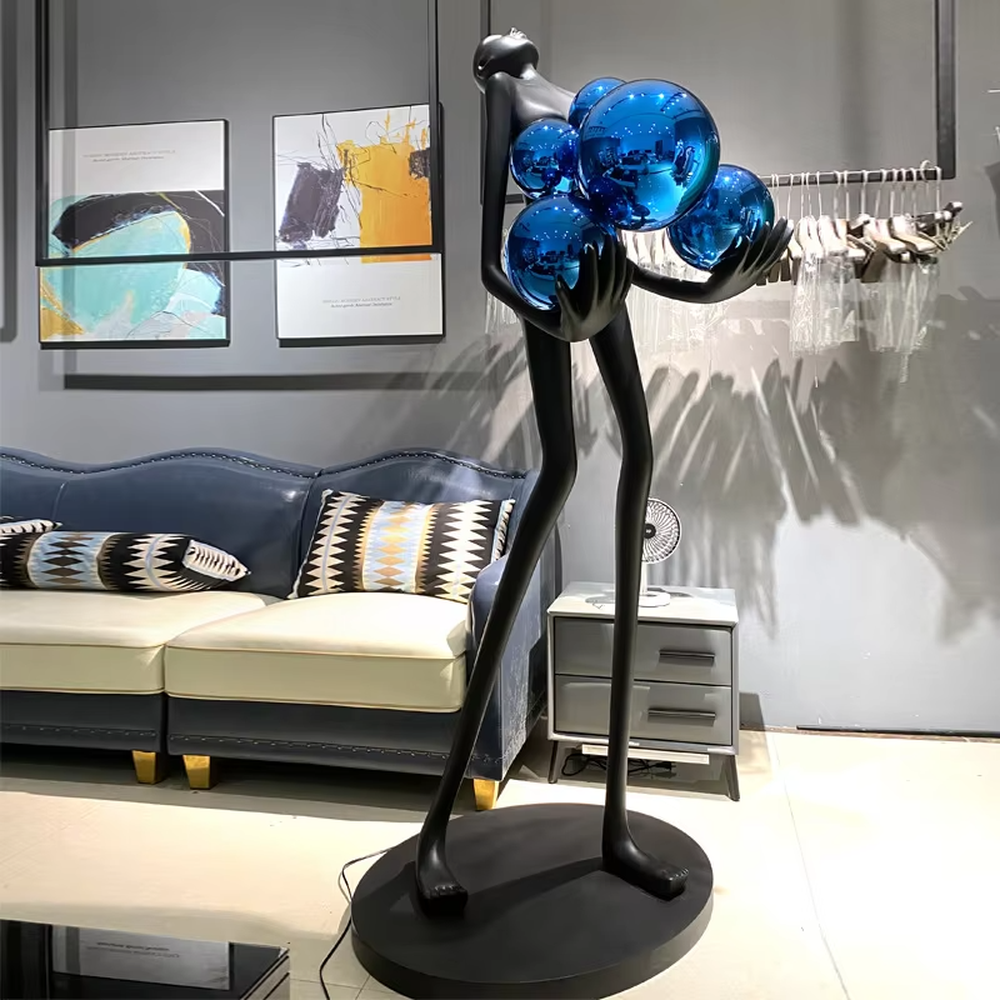 This is an artistic human-shaped floor lamp, featuring a black human sculpture holding a circular luminous lamp, with a white marble base. It has a strong artistic sense and modern luxury style. It is used for space lighting and decoration, creating an artistic atmosphere. It is suitable for modern art home living rooms, high-end hotel lobbies, art exhibition halls and other places.