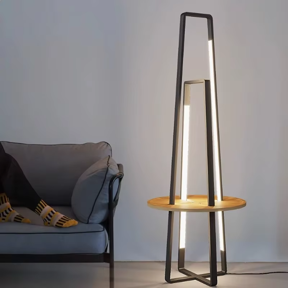 This is a modern geometric double-frame floor lamp with a black metal geometric frame, a wooden storage table, and built-in LED light strips, featuring a minimalist modern and functional design. It is used for space lighting, storage, and decoration, creating a modern luxury atmosphere. It is suitable for modern home living rooms, creative studios, luxury-style residences and other places.
