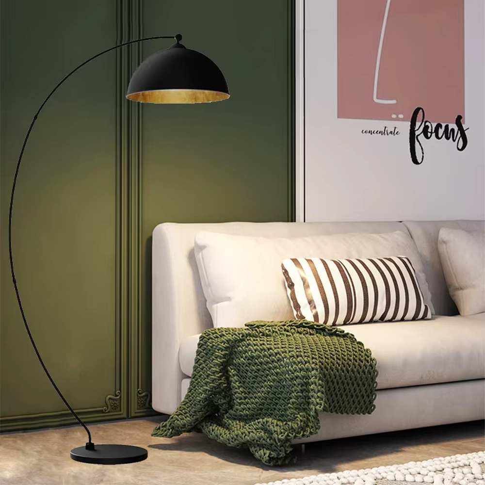 This is a modern minimalist light luxury curved floor lamp, with a black curved lamp pole paired with a black-outside-gold-inside hemisphere lampshade, and a black disc base. The lighting is soft and warm, creating a minimalist high-end atmosphere.