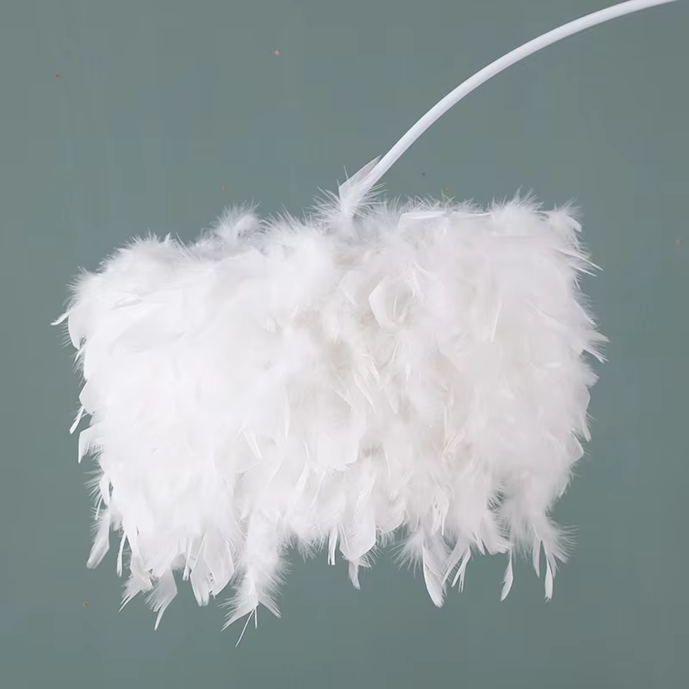 This is a warm romantic-style curved feather floor lamp, with a black curved lamp pole paired with a white feather lampshade, and a small tray (for storage). The lighting is soft and warm, creating a comfortable romantic atmosphere.