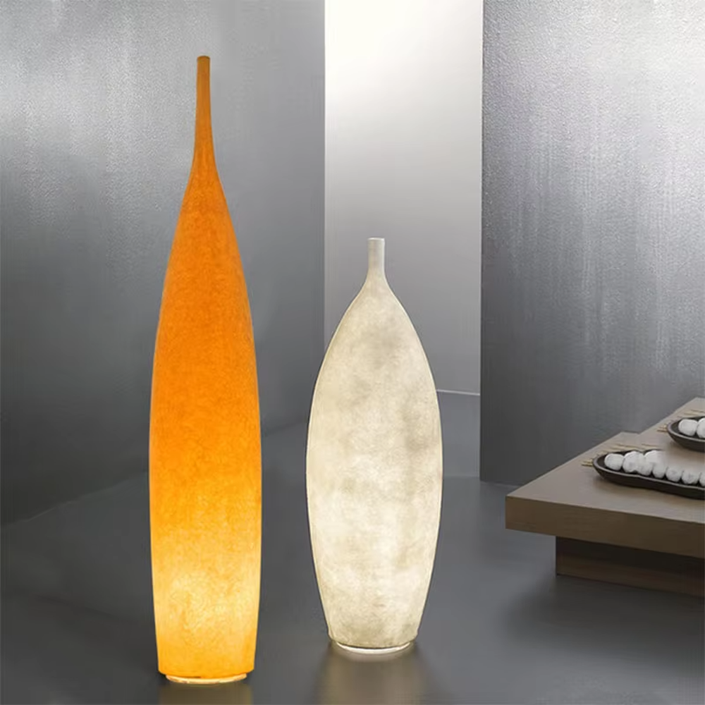 This is a Zen minimalist bottle-shaped paper art floor lamp (including large and small styles), made of light beige paper art texture material to create a slender bottle shape, with a large and small combination design. The light through the material is soft and hazy, creating a quiet and elegant atmosphere. It is used for space lighting and decoration, suitable for Zen-style spaces, minimalist homes and other places.