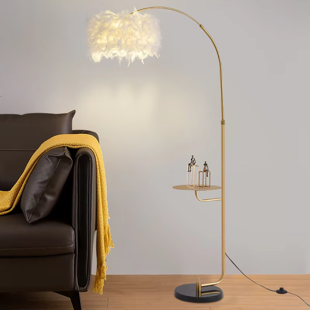 This is a warm romantic-style curved feather floor lamp, with a black curved lamp pole paired with a white feather lampshade, and a small tray (for storage). The lighting is soft and warm, creating a comfortable romantic atmosphere.