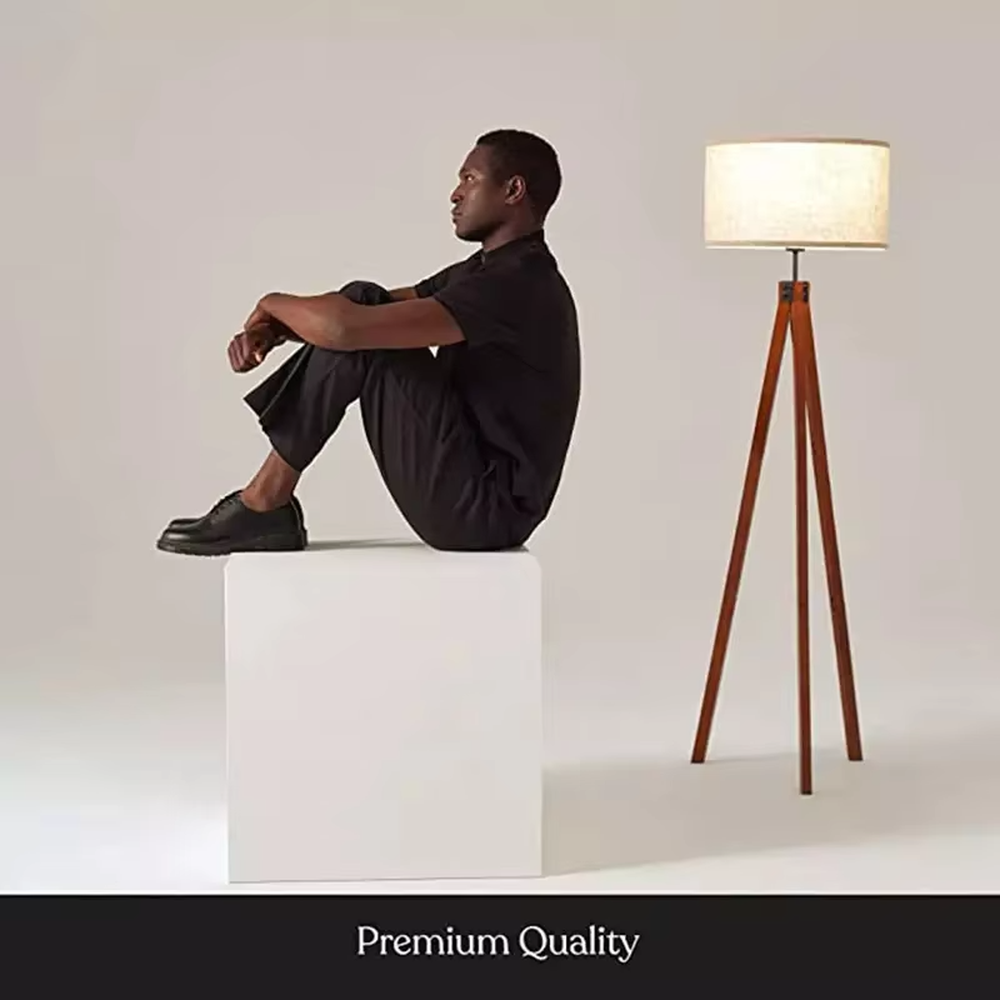 Vintage natural-style reddish-brown wooden tripod floor lamp, paired with beige fabric lampshade, soft and warm lighting, creating a natural and comfortable space atmosphere.
