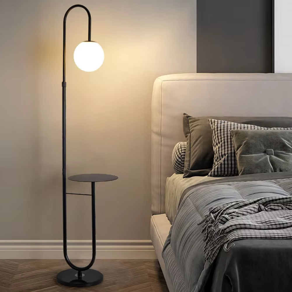 Modern light luxury golden curved floor lamp with table, white spherical lampshade + marble-patterned base, soft lighting, integrating lighting and storage functions, creating a minimalist high-end atmosphere.