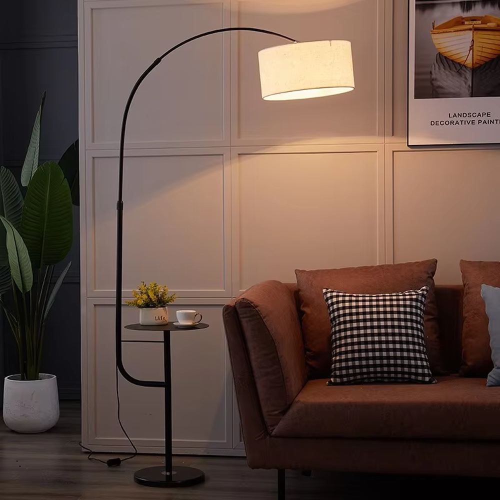 Warm romantic-style white curved feather floor lamp with a small round storage table, white feather lampshade + white lamp pole + round base, soft and warm lighting, creating a comfortable romantic space atmosphere.