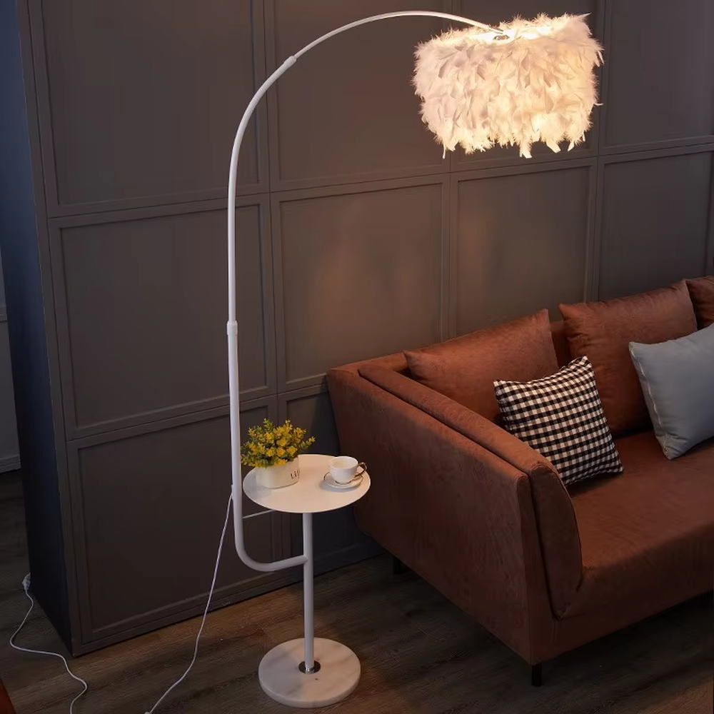 Warm romantic-style white curved feather floor lamp with a small round storage table, white feather lampshade + white lamp pole + round base, soft and warm lighting, creating a comfortable romantic space atmosphere.