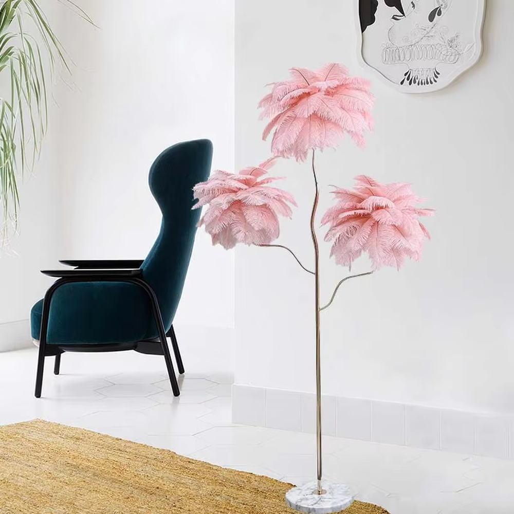 This is a light luxury soft feather-shaped floor lamp, equipped with three white feather lampshades, paired with a golden curved lamp pole and a marble base. The design is gentle and elegant, with soft and hazy lighting through the feathers. It is used for space lighting and decoration, creating a warm and soft light luxury atmosphere. Suitable for light luxury-style living rooms, bedrooms, internet-famous homestays and other places.