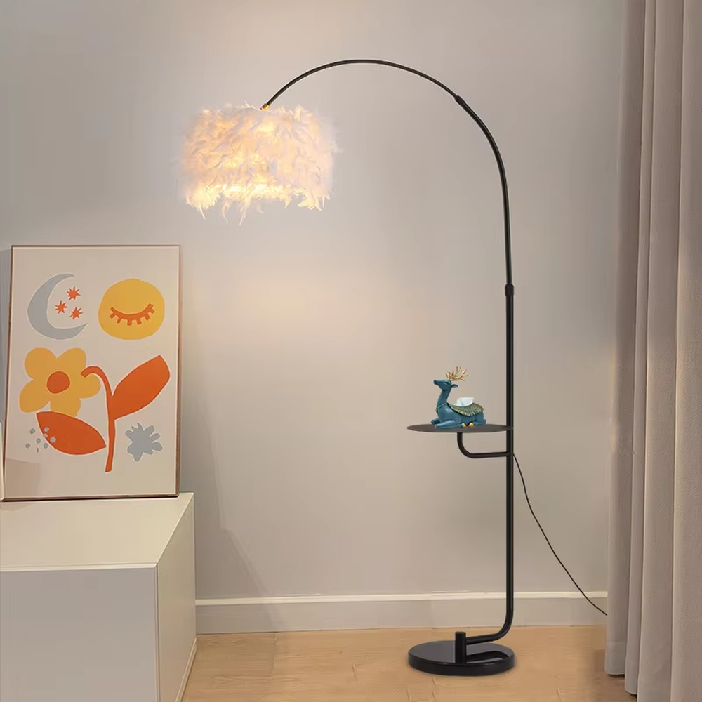 This is a warm romantic-style curved feather floor lamp, with a black curved lamp pole paired with a white feather lampshade, and a small tray (for storage). The lighting is soft and warm, creating a comfortable romantic atmosphere.