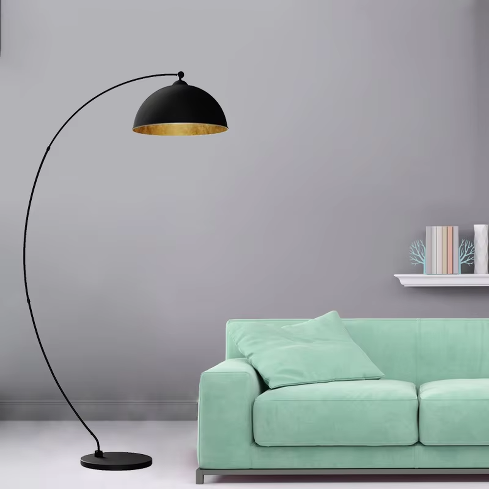 This is a modern minimalist light luxury curved floor lamp, with a black curved lamp pole paired with a black-outside-gold-inside hemisphere lampshade, and a black disc base. The lighting is soft and warm, creating a minimalist high-end atmosphere.
