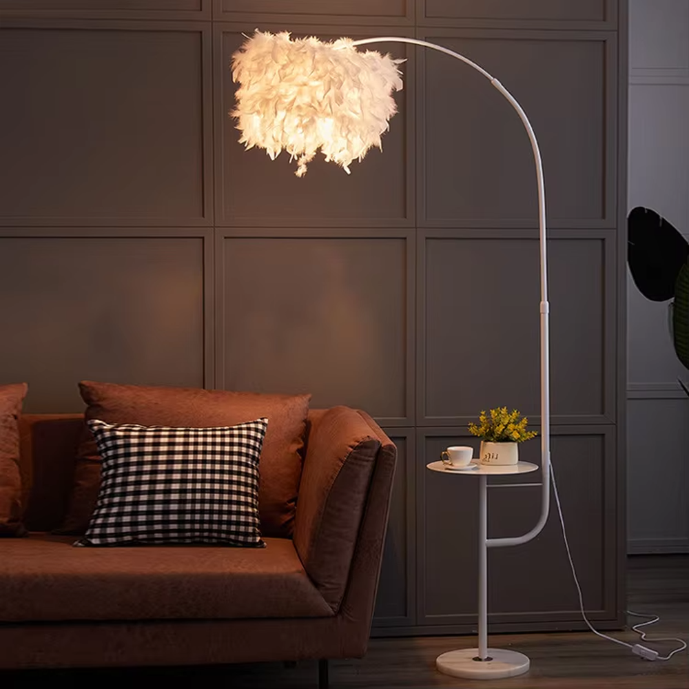 Warm romantic-style white curved feather floor lamp with a small round storage table, white feather lampshade + white lamp pole + round base, soft and warm lighting, creating a comfortable romantic space atmosphere.