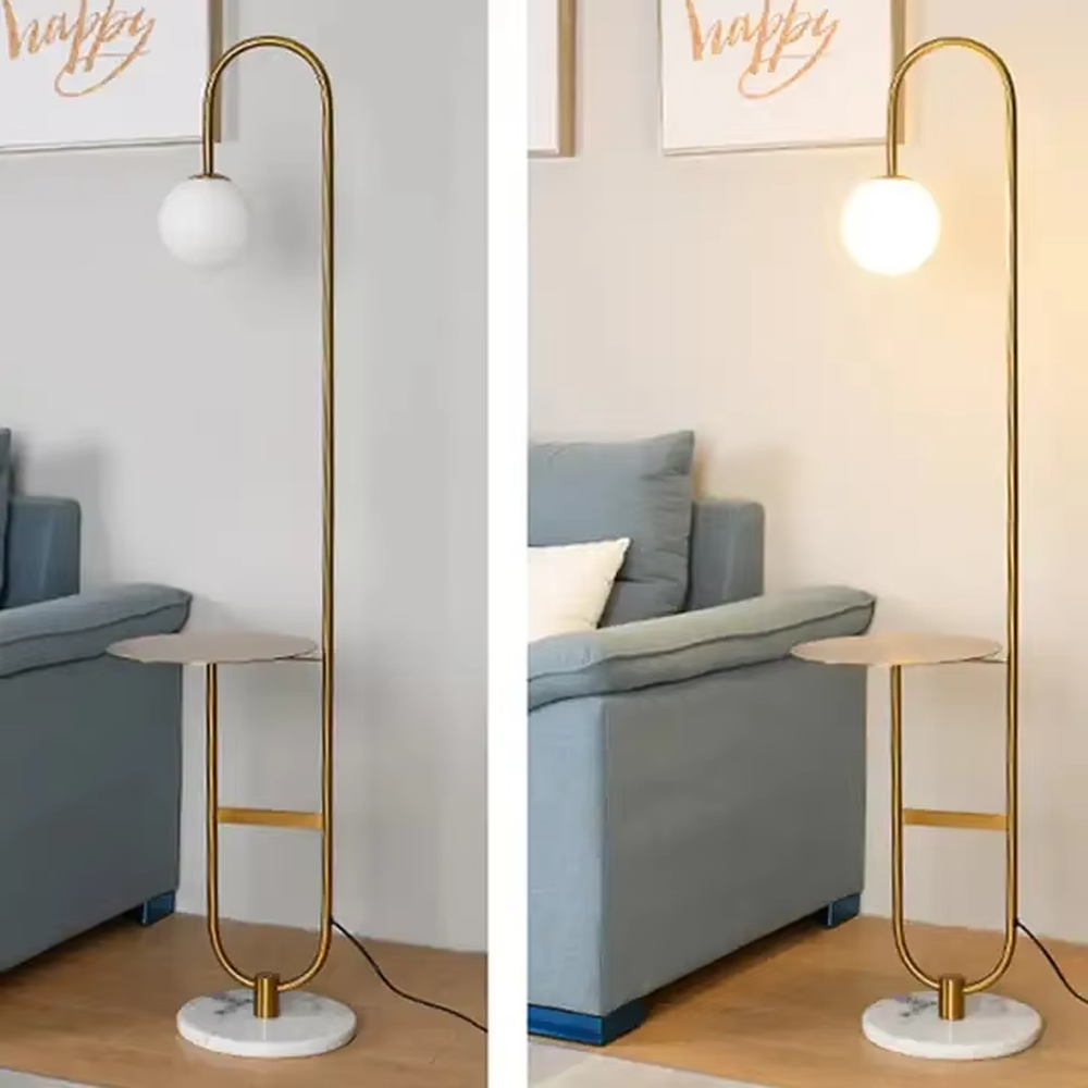 Modern light luxury golden curved floor lamp with table, white spherical lampshade + marble-patterned base, soft lighting, integrating lighting and storage functions, creating a minimalist high-end atmosphere.