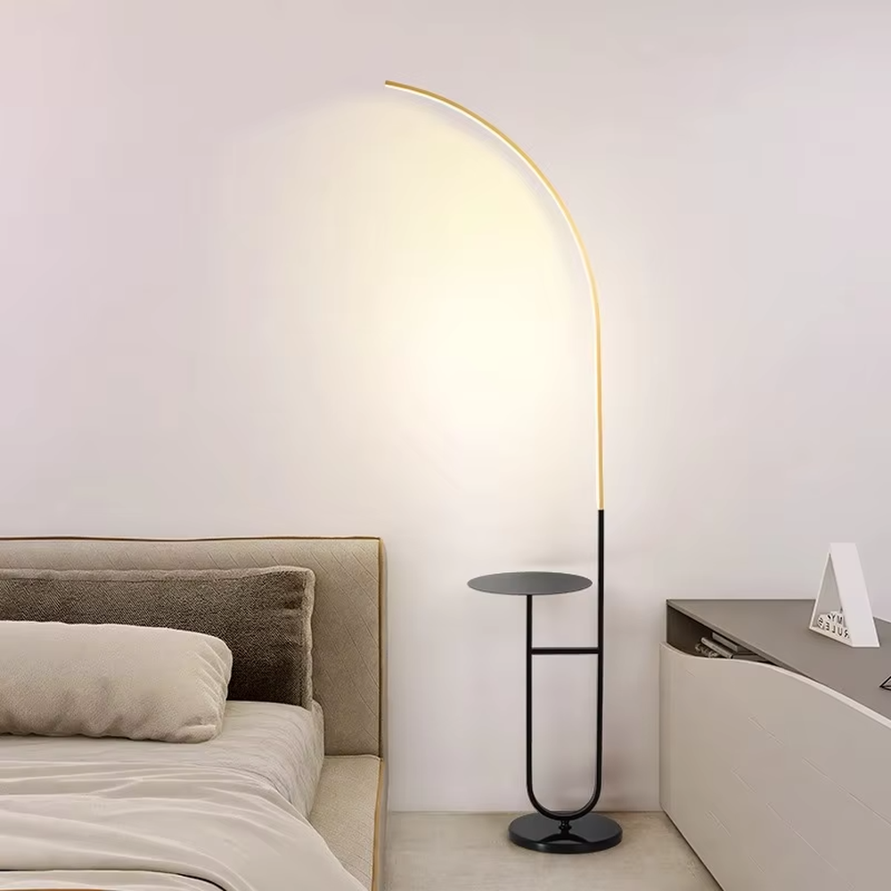 Modern minimalist black metal curved LED floor lamp (with round small side table), soft and uniform warm light, creating a simple practical home atmosphere.