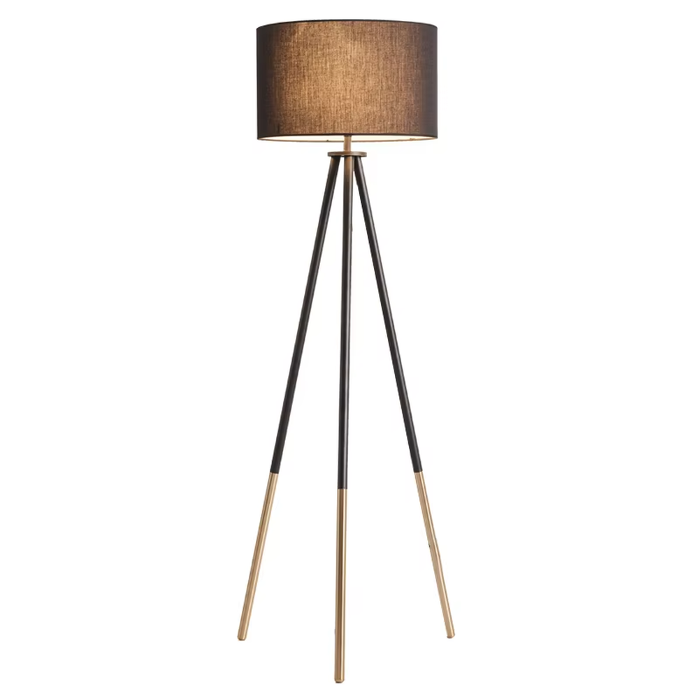 Light luxury black-gold spliced tripod floor lamp, brown fabric cylindrical lampshade + black pole gold foot stand, soft lighting, creating a high-end minimalist atmosphere.