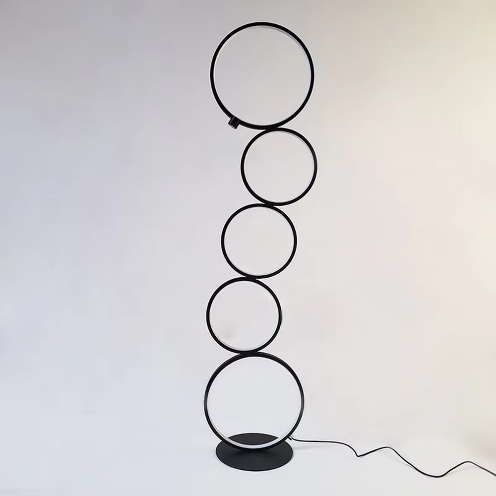 Modern art-style multi-layer luminous ring floor lamp, black frame + warm light ring light source + stacked shape, creating a simple artistic space atmosphere.