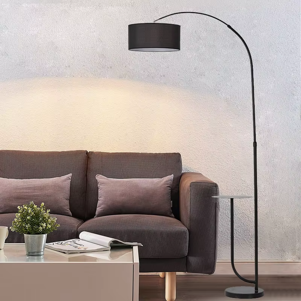 Minimalist black metal curved floor lamp with side table, black metal stand + black fabric lampshade + matching small side table, soft light, creating a minimalist high-end home atmosphere.