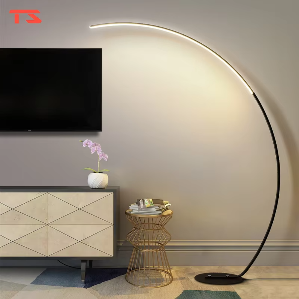 Modern minimalist black metal curved strip LED floor lamp, black metal curved stand + strip LED lamp body + soft warm light, creating a simple high-end home atmosphere.