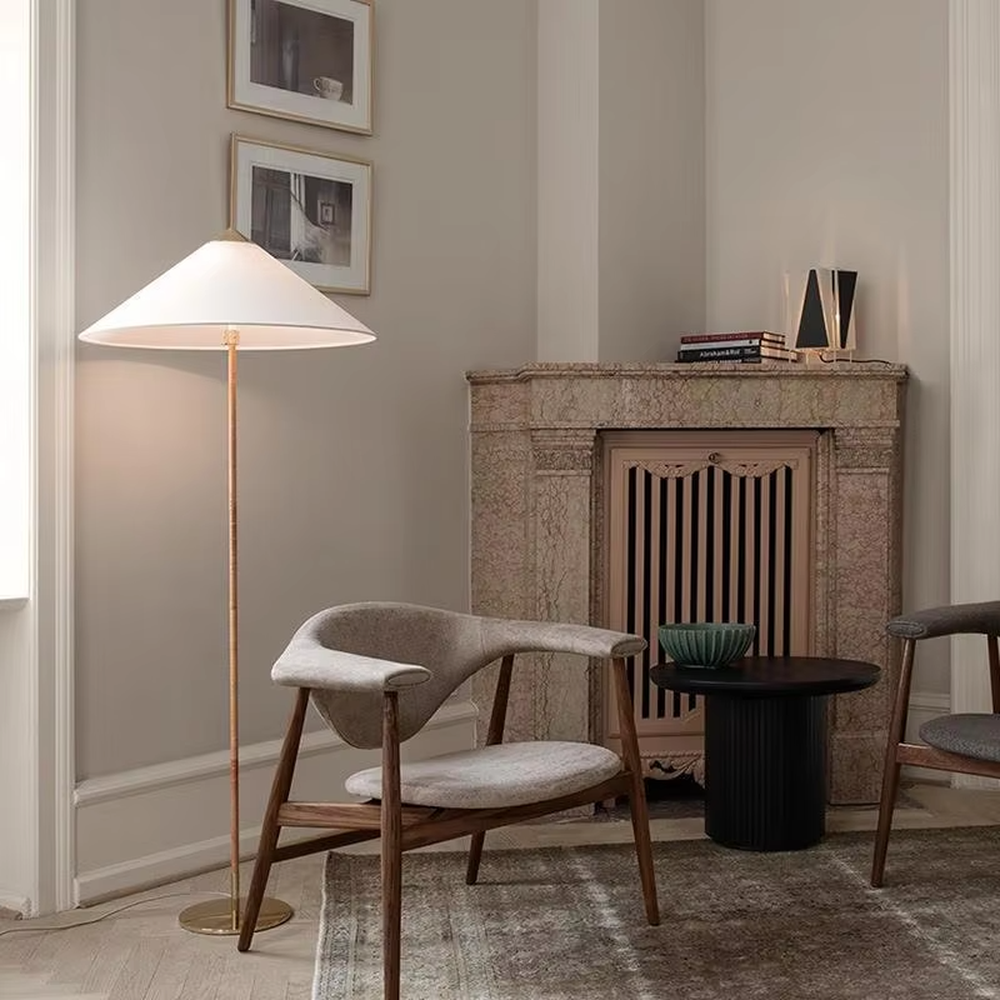 Light luxury vintage-style golden woven pole cone lampshade floor lamp, white cone fabric lampshade + golden disc base, soft lighting, creating an elegant vintage atmosphere.