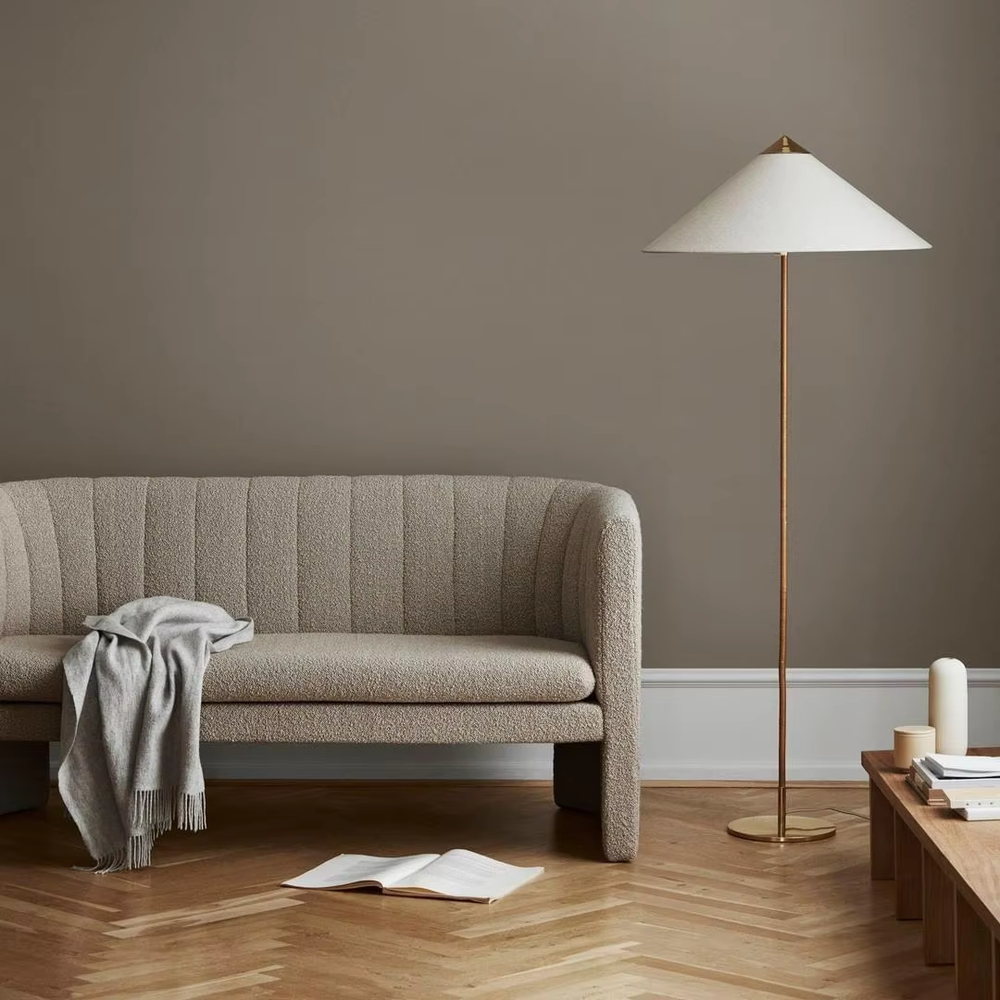 Light luxury vintage-style golden woven pole cone lampshade floor lamp, white cone fabric lampshade + golden disc base, soft lighting, creating an elegant vintage atmosphere.