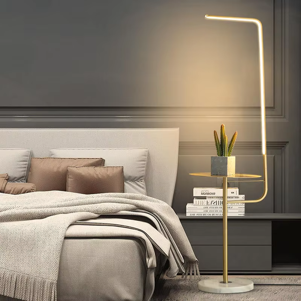 Light luxury golden L-shaped LED strip floor lamp with transparent side table, golden metal L-shaped stand + transparent round side table + white marble base, soft warm light, creating a high-end practical light luxury atmosphere.