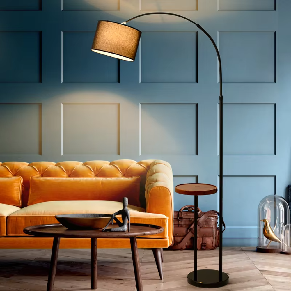 Vintage light luxury black metal curved floor lamp with side table, black metal stand + brown fabric lampshade + wooden small side table, soft warm light, creating a vintage elegant home atmosphere.