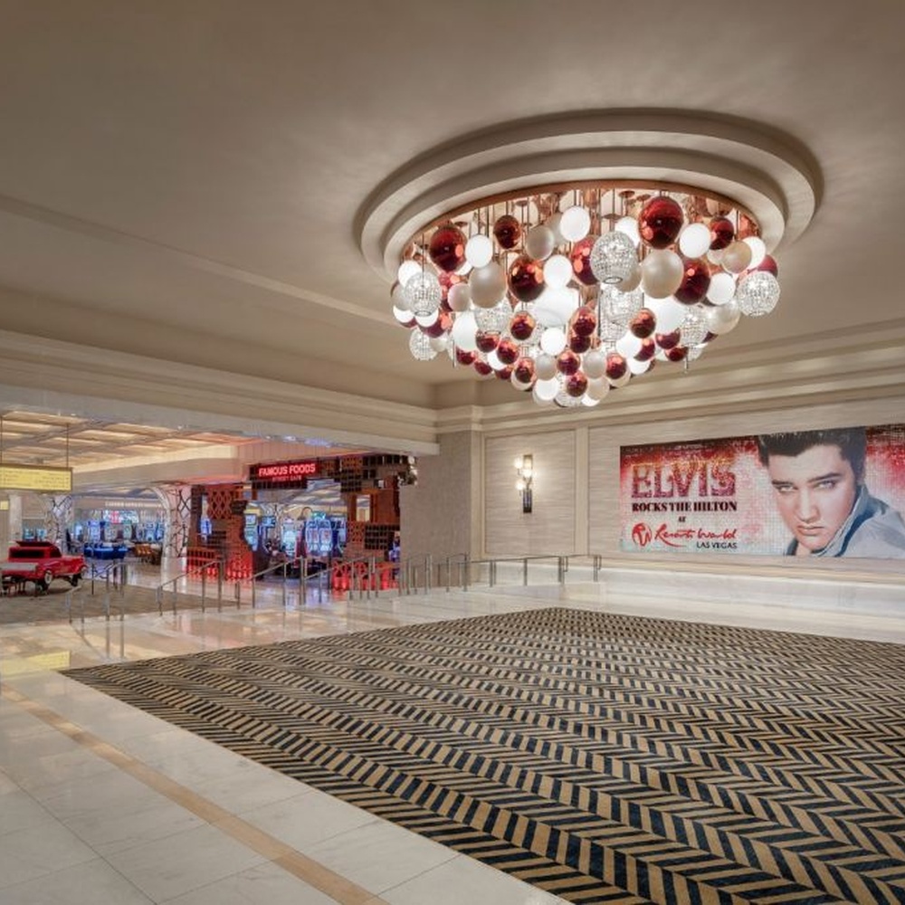 This is a modern luxury style cluster spherical chandelier, composed of red, white and silver glass balls arranged in a staggered manner, embedded in a circular ceiling structure, which has both lighting and artistic decoration functions, suitable for large commercial spaces such as hotel lobbies, shopping mall atriums, and high-end clubs.