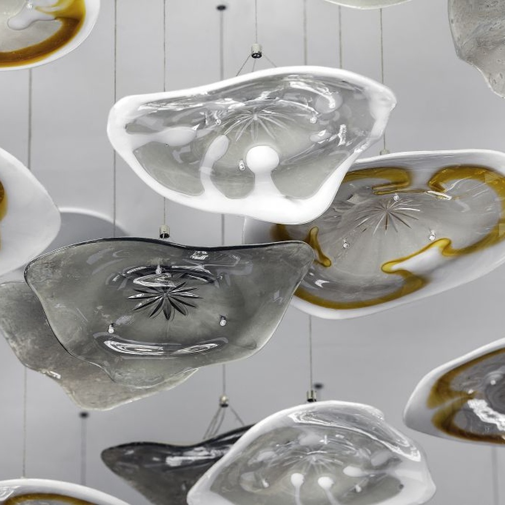 This modern art cloud-slice chandelier consists of irregular transparent and gold cloud-shaped ornaments hung staggered, as light as floating clouds. Light passes through the ornaments to emit a soft and transparent halo, serving both lighting and decorative purposes, suitable for high-end commercial spaces such as luxury sales offices and clubs.