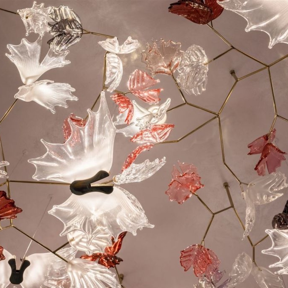 This is a customized artistic flower ceiling chandelier, composed of flower and branch-shaped components made of transparent and red-pink glass/acrylic material, paired with a circular luminous ceiling plate, which has both lighting and artistic decoration functions, suitable for large commercial spaces such as hotel lobbies, banquet halls, and high-end clubs.