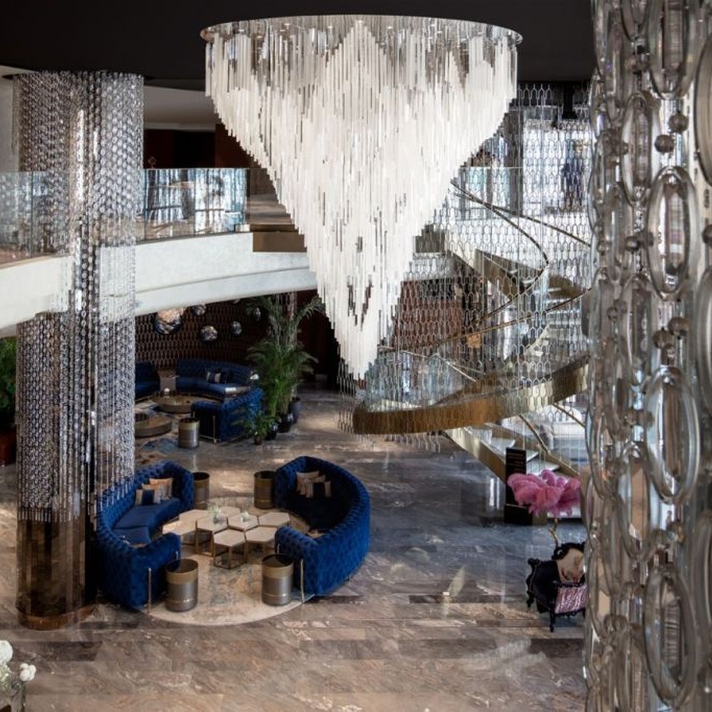 Modern Art Waterdrop Rain Curtain Crystal Chandelier, composed of numerous white transparent crystal/acrylic strips suspended in an irregular waterdrop shape, serves both lighting and decorative purposes, ideal for luxury hotel lobbies, sales centers, high-end clubs, art galleries and other high-ceiling public spaces.