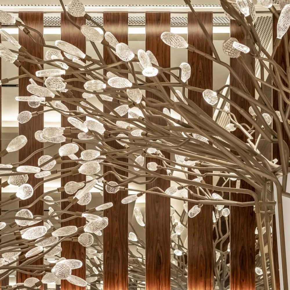 This new Chinese artistic tree-shaped chandelier features a metal branch frame paired with transparent light-emitting leaf-shaped ornaments, presenting a visual effect of blooming flower trees, serving both lighting and decorative purposes, suitable for large spaces such as hotel lobbies and high-end clubs.
