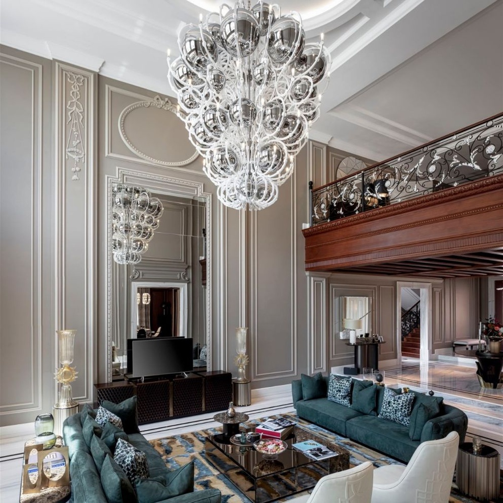 This European luxury art crystal chandelier is made of hand-blown transparent glass/crystal, with an irregular curled and twisted shape that presents a visual effect like a blooming firework. The light refracts through the crystal to emit a brilliant glow, serving both lighting and decorative purposes, suitable for luxury spaces such as high-ceiling villa living rooms and high-end clubs.