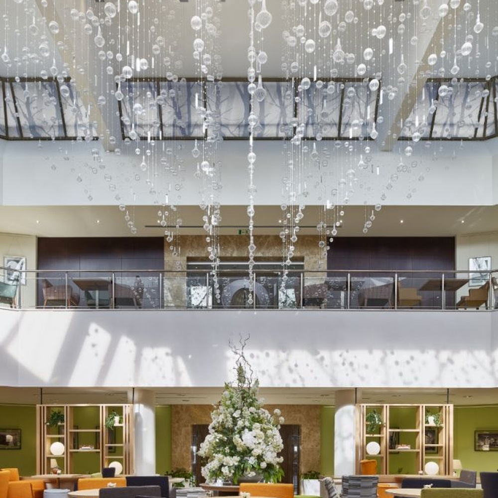 This large artistic bubble chandelier is composed of a large number of transparent glass bubble balls hung in a staggered manner by metal wires, presenting a visual effect like scattered starry sky. The light refracts through the bubbles to emit soft and transparent light spots, serving both lighting and decorative purposes, suitable for high-ceiling commercial spaces such as hotel lobbies and shopping mall atriums.