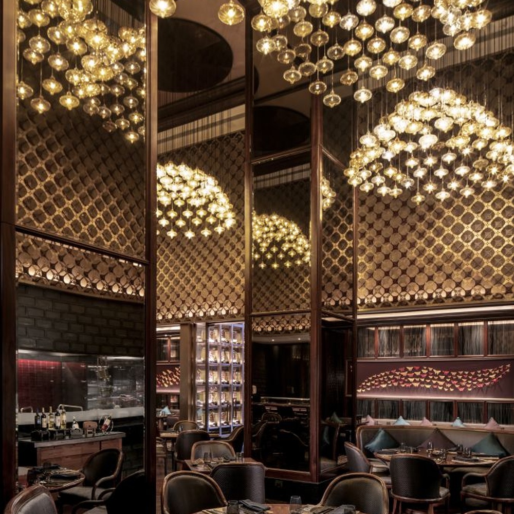This light luxury bubble cloud chandelier is composed of a large number of transparent glass bubble lamp heads, arranged in a hemispherical staggered manner. Warm light refracts through the bubbles to emit soft and brilliant light spots, serving both lighting and decorative purposes, suitable for high-end restaurants, clubs and other light luxury style spaces.