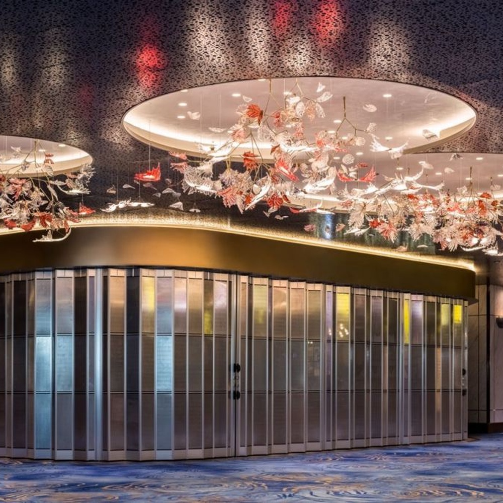 This is a customized artistic flower ceiling chandelier, composed of flower and branch-shaped components made of transparent and red-pink glass/acrylic material, paired with a circular luminous ceiling plate, which has both lighting and artistic decoration functions, suitable for large commercial spaces such as hotel lobbies, banquet halls, and high-end clubs.