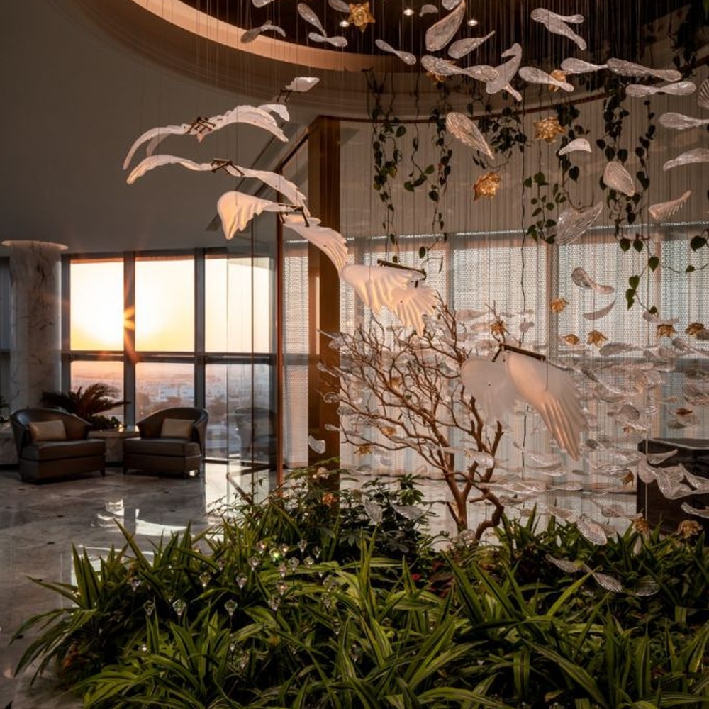 This is a natural-style suspended art installation lamp, composed of transparent ripple-shaped leaves and gold accents, creating an immersive scene with dead trees and green plants, with both decorative and lighting functions, ideal for weddings, high-end restaurants, art galleries and other scenarios.