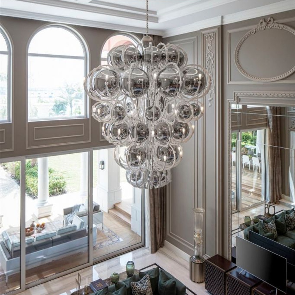 This European luxury art crystal chandelier is made of hand-blown transparent glass/crystal, with an irregular curled and twisted shape that presents a visual effect like a blooming firework. The light refracts through the crystal to emit a brilliant glow, serving both lighting and decorative purposes, suitable for luxury spaces such as high-ceiling villa living rooms and high-end clubs.