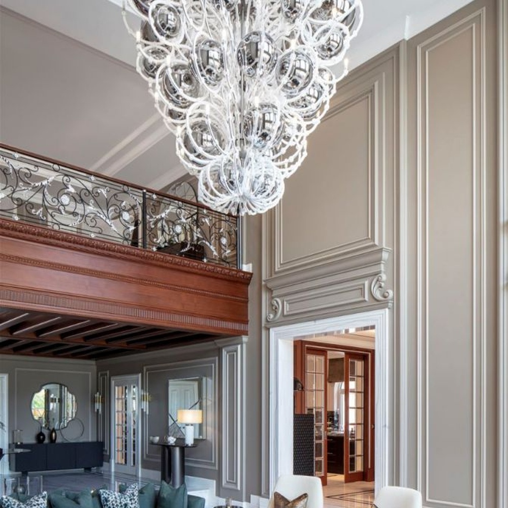 This European luxury art crystal chandelier is made of hand-blown transparent glass/crystal, with an irregular curled and twisted shape that presents a visual effect like a blooming firework. The light refracts through the crystal to emit a brilliant glow, serving both lighting and decorative purposes, suitable for luxury spaces such as high-ceiling villa living rooms and high-end clubs.