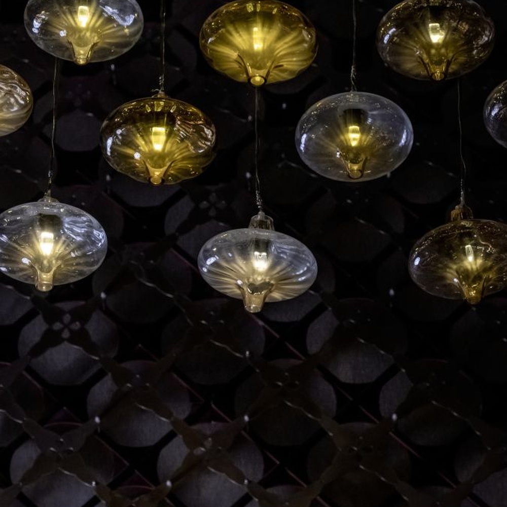 This light luxury bubble cloud chandelier is composed of a large number of transparent glass bubble lamp heads, arranged in a hemispherical staggered manner. Warm light refracts through the bubbles to emit soft and brilliant light spots, serving both lighting and decorative purposes, suitable for high-end restaurants, clubs and other light luxury style spaces.