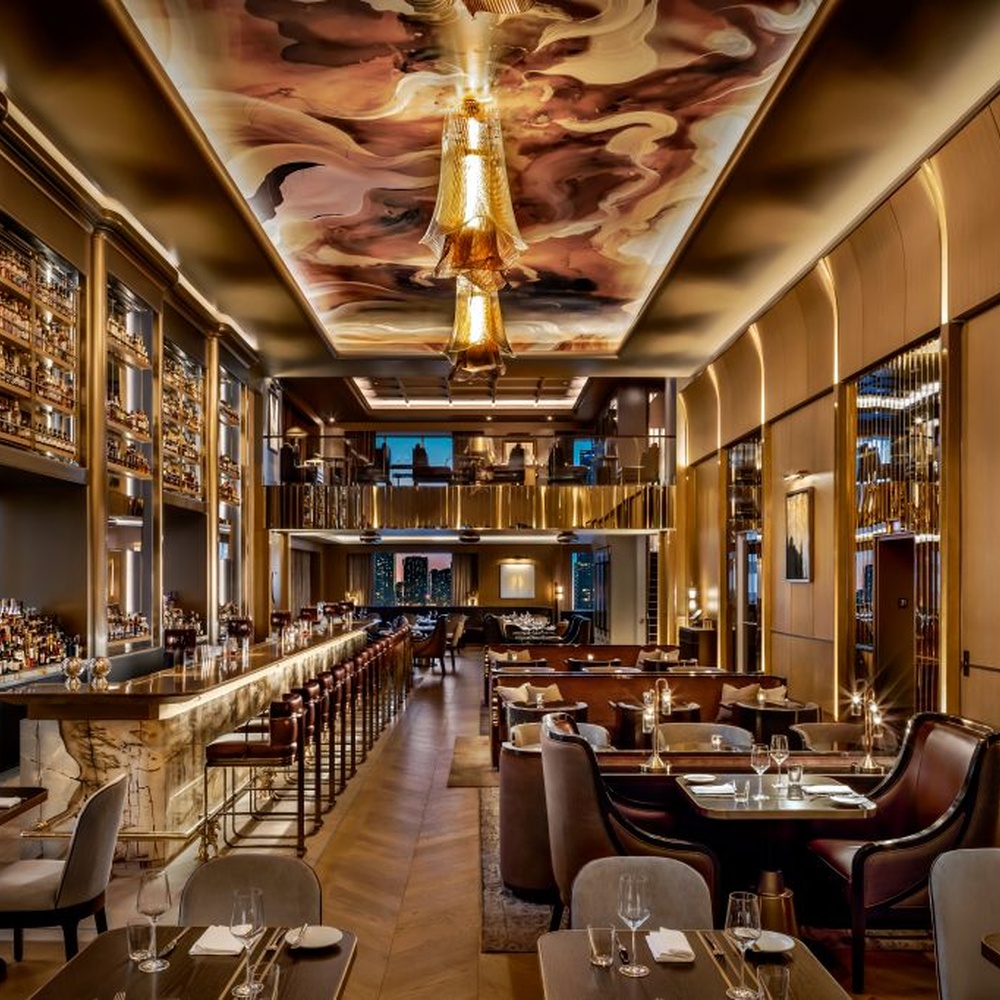 This modern light luxury art chandelier is made of metal mesh/acrylic material with a layered streamlined shape, hanging down like flowing fabric. Warm light passes through the material to emit a soft and transparent halo, serving both lighting and decorative purposes, suitable for high-end commercial spaces such as luxury restaurants and clubs.