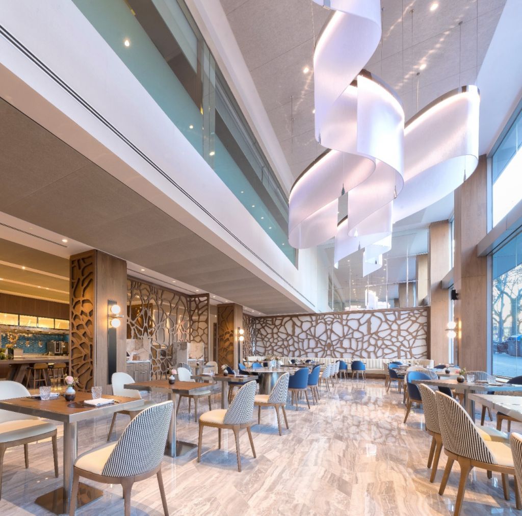 This is a modern minimalist large layered chandelier, crafted with white fabric/acrylic to create a rounded lantern shape, hung in a staggered multi-layer arrangement, with soft and uniform light, featuring both decorative and lighting functions, ideal for high-end restaurants, hotel lobbies and other commercial spaces.