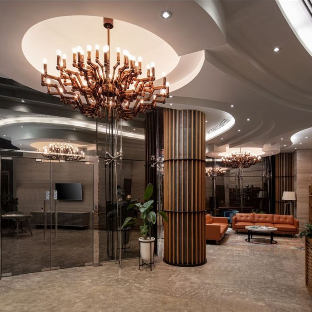 This branch-shaped multi-head chandelier features a fork-shaped lamp frame made of wood-like material, paired with multiple groups of staggered light-emitting lamp heads, presenting a visual effect that combines natural artistry and modern industrial style, suitable for core lighting and decoration in high-ceiling public spaces.