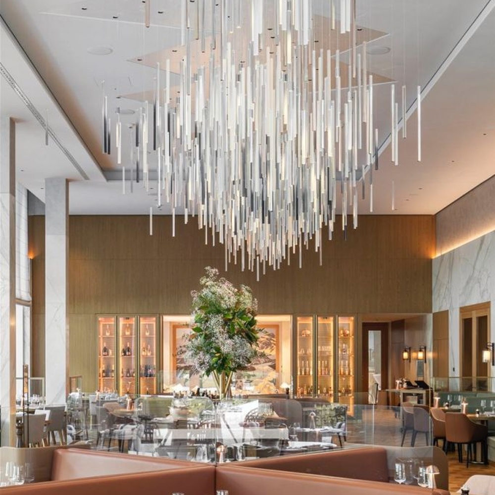 This is a modern minimalist large pendant crystal chandelier, composed of densely hung transparent and translucent crystal tubes, creating a dynamic light waterfall effect, with both decorative and lighting functions, ideal for high-ceiling commercial spaces such as high-end restaurants and hotel lobbies.